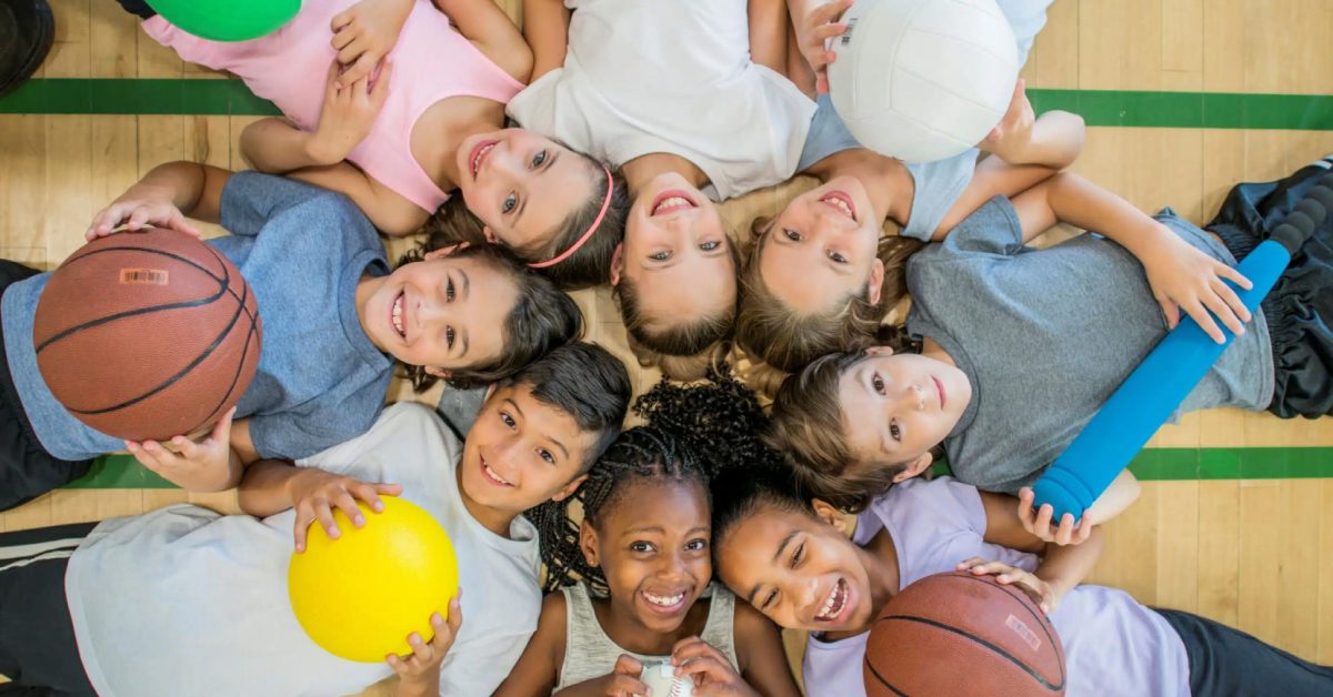 Group of young athletes with various sports balls